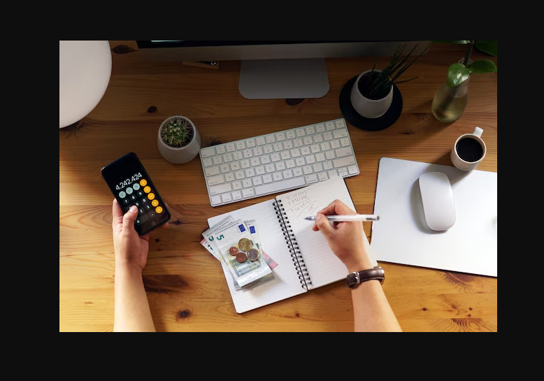 Construction project cash flow management with calculator, notebook, and currency.